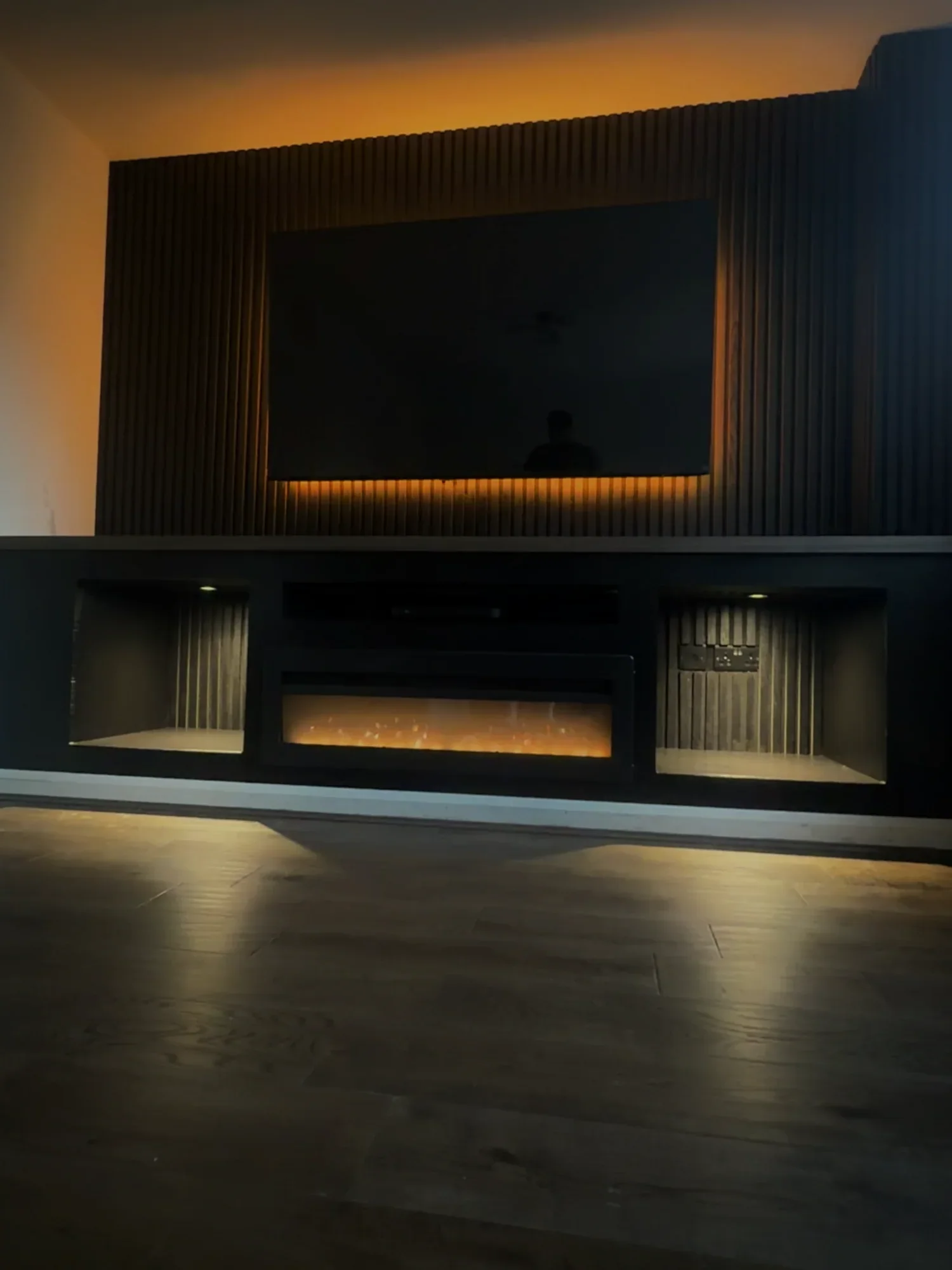 Slatted media wall with integrated television, fireplace and lighting
