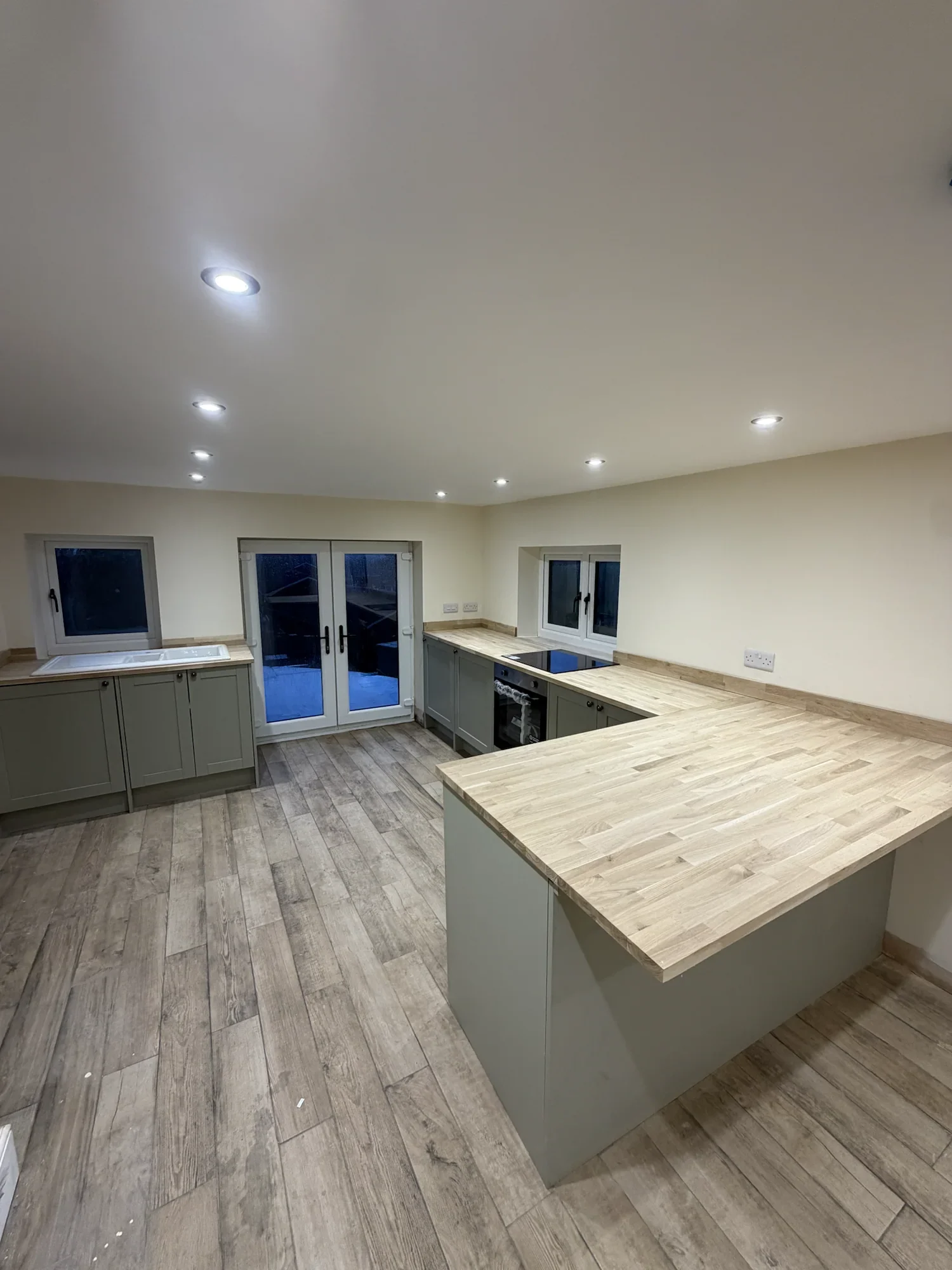 Completed farmhouse kitchen with shaker cabinetry and timber worktops