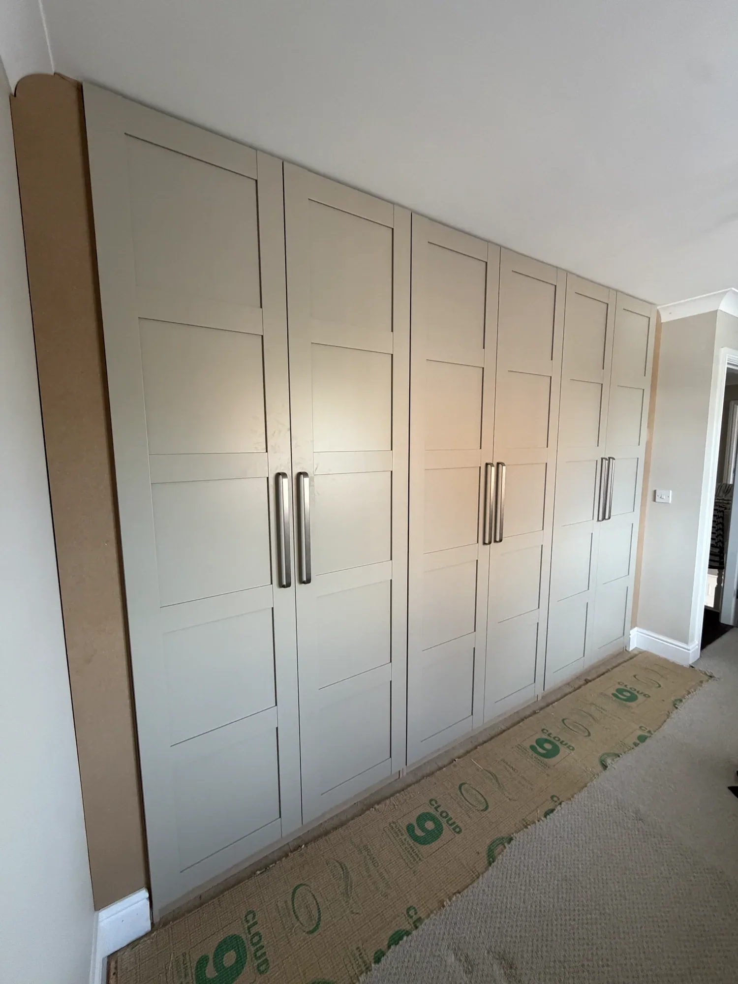 Floor-to-ceiling fitted wardrobes with panelled doors